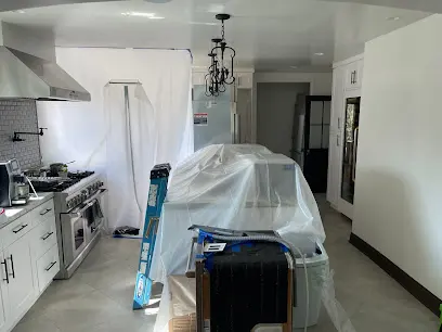 Kitchen sealed off with plastic containment while drying equipment runs during a water damage cleanup