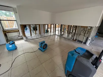 Air mover drying a Duarte room with the lower section of the wall opened and the cavity exposed to air