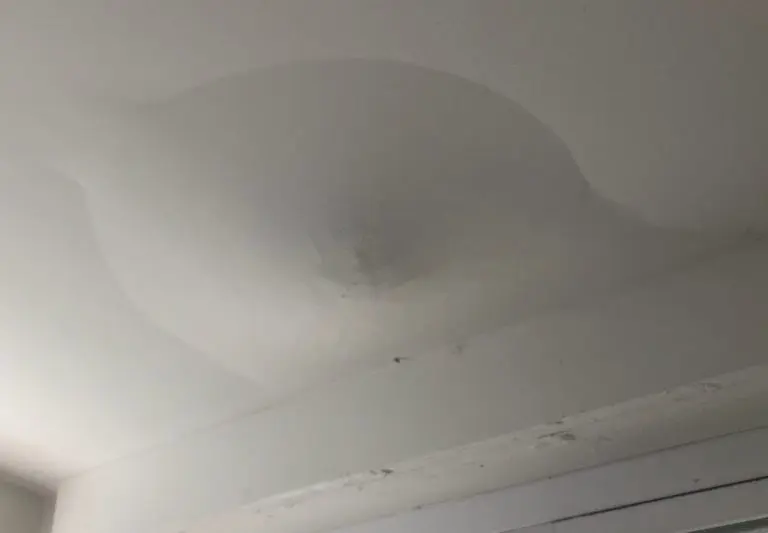 Ceiling drywall sagging and stained where water collected above it
